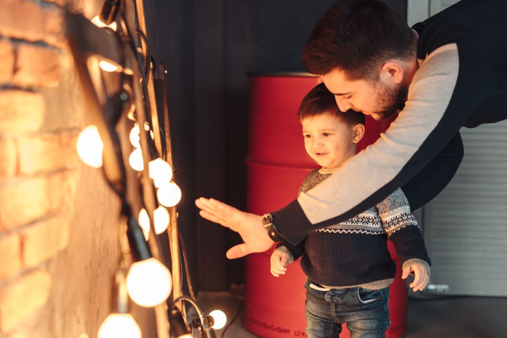 Father and child enjoying holiday lights together