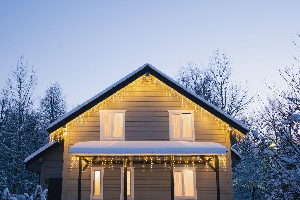 Snowy home with warm icicle lights