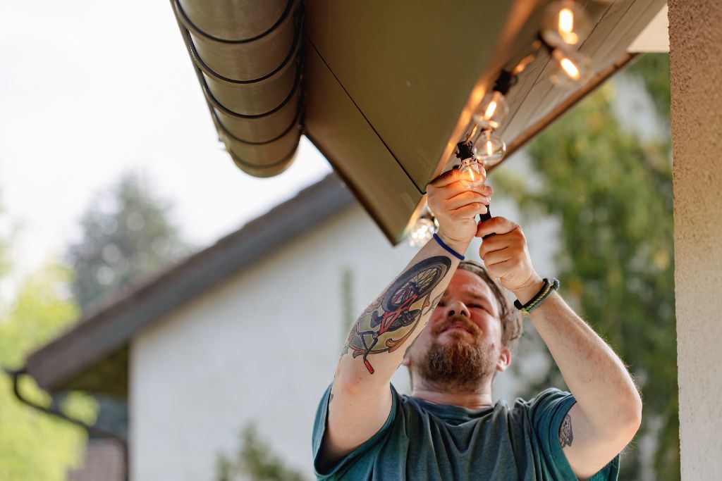 Technician carefully installing outdoor string lights
